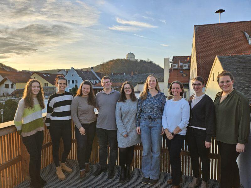 Gruppenfoto auf dem Balkon, im Hintergrund Häuser