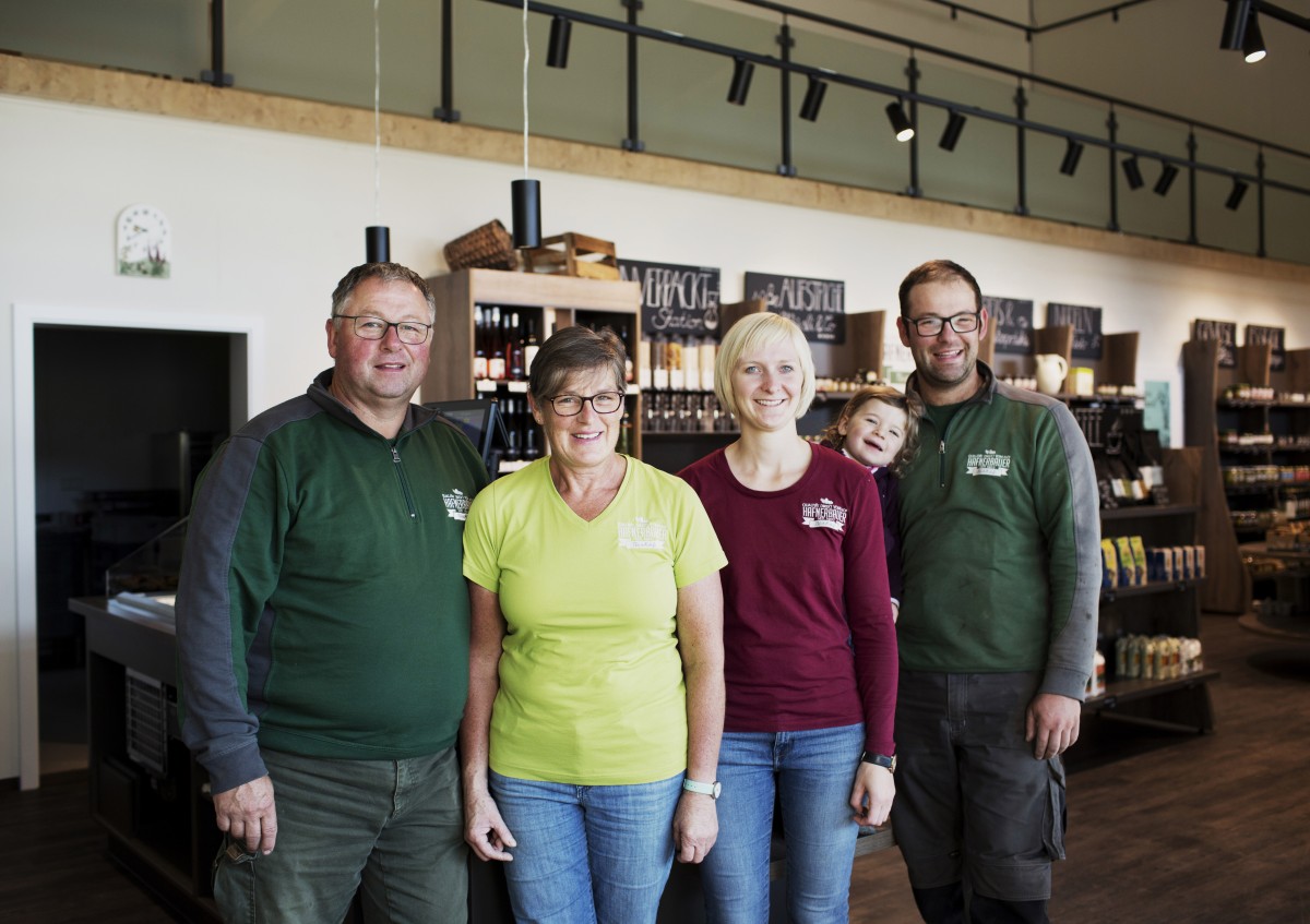 Das Foto zeigt eine Familie mit Großeltern, Eltern und einem Kleinkind in einem Geschäft.