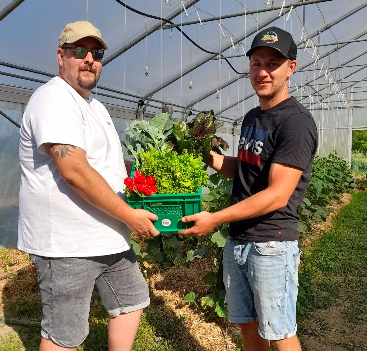 Robert aus Fridolfing (links) war einer der ersten Neuabonennten, der sich seine Gemüsekiste bei Biobauer Markus Hager abholte.