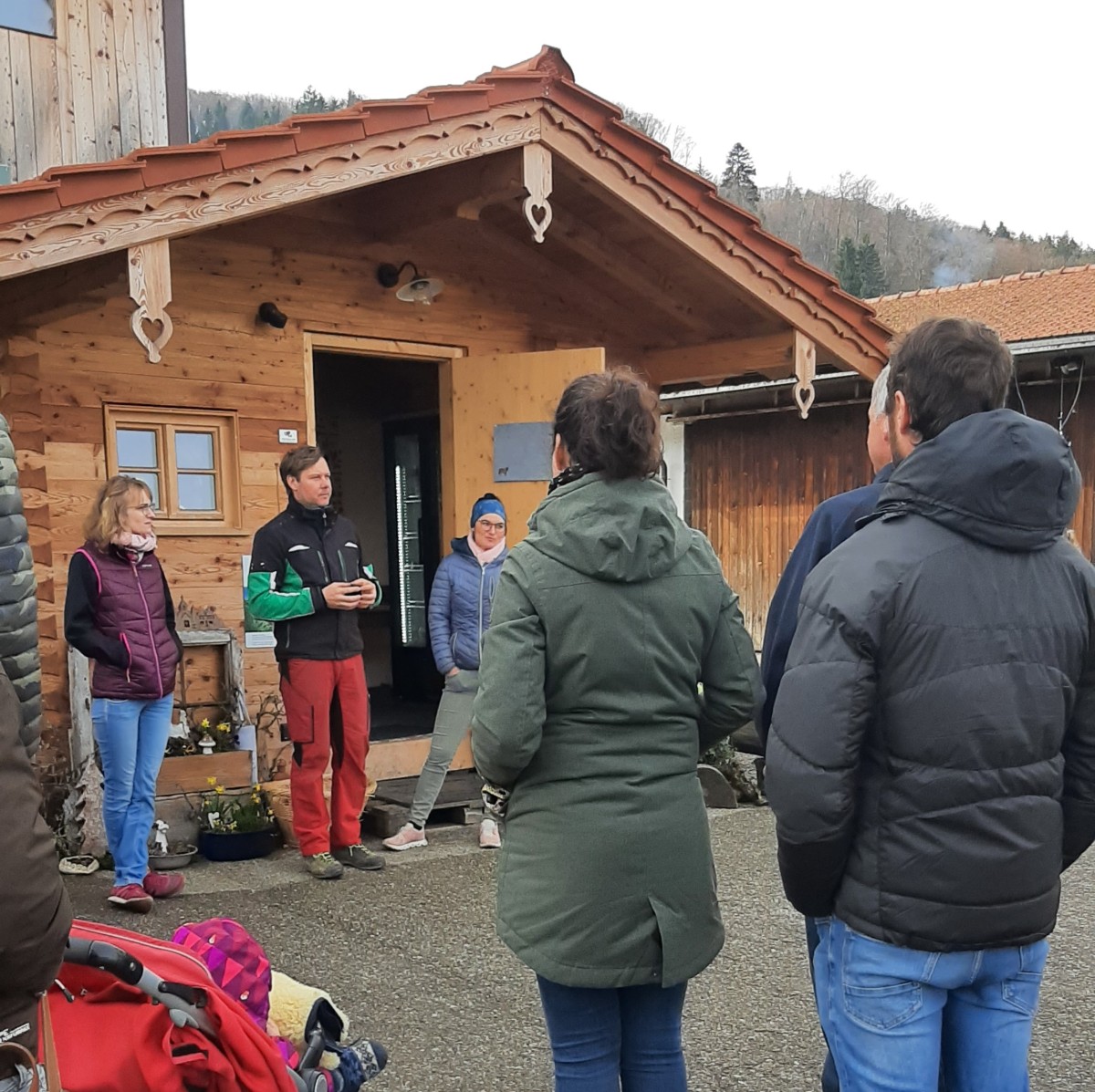 Katharina und Andreas Wimmer stehen vor ihrem Hofladen und erklären Besuchern ihr Hofkonzept