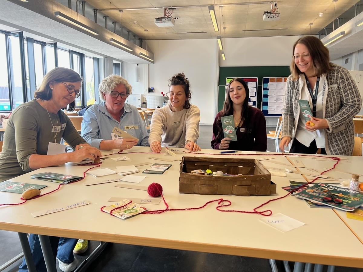 Personen an einem Tisch wählen Kärtchen oder Gegenstände für das Spiel aus