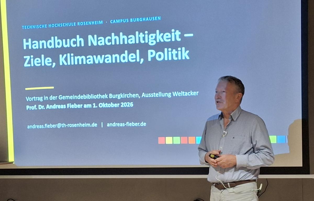 Mann steht vor der Leinwand mit dortiger Präsentation.