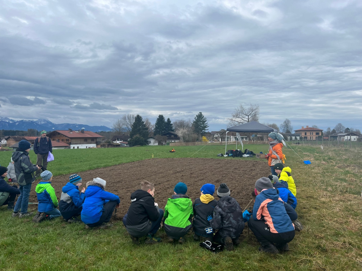 Kinder sitzen am Acker