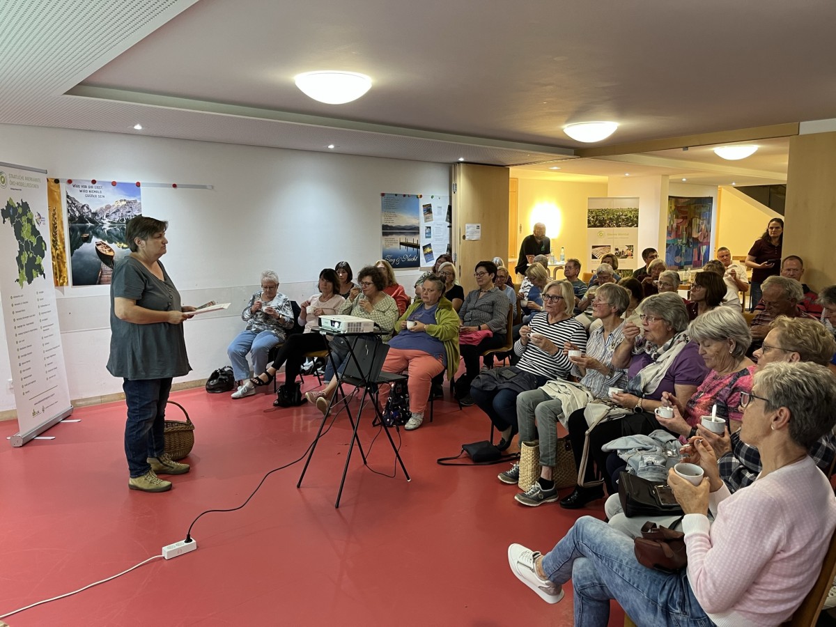 Referienende Frau vor einem sitzenden Publikum