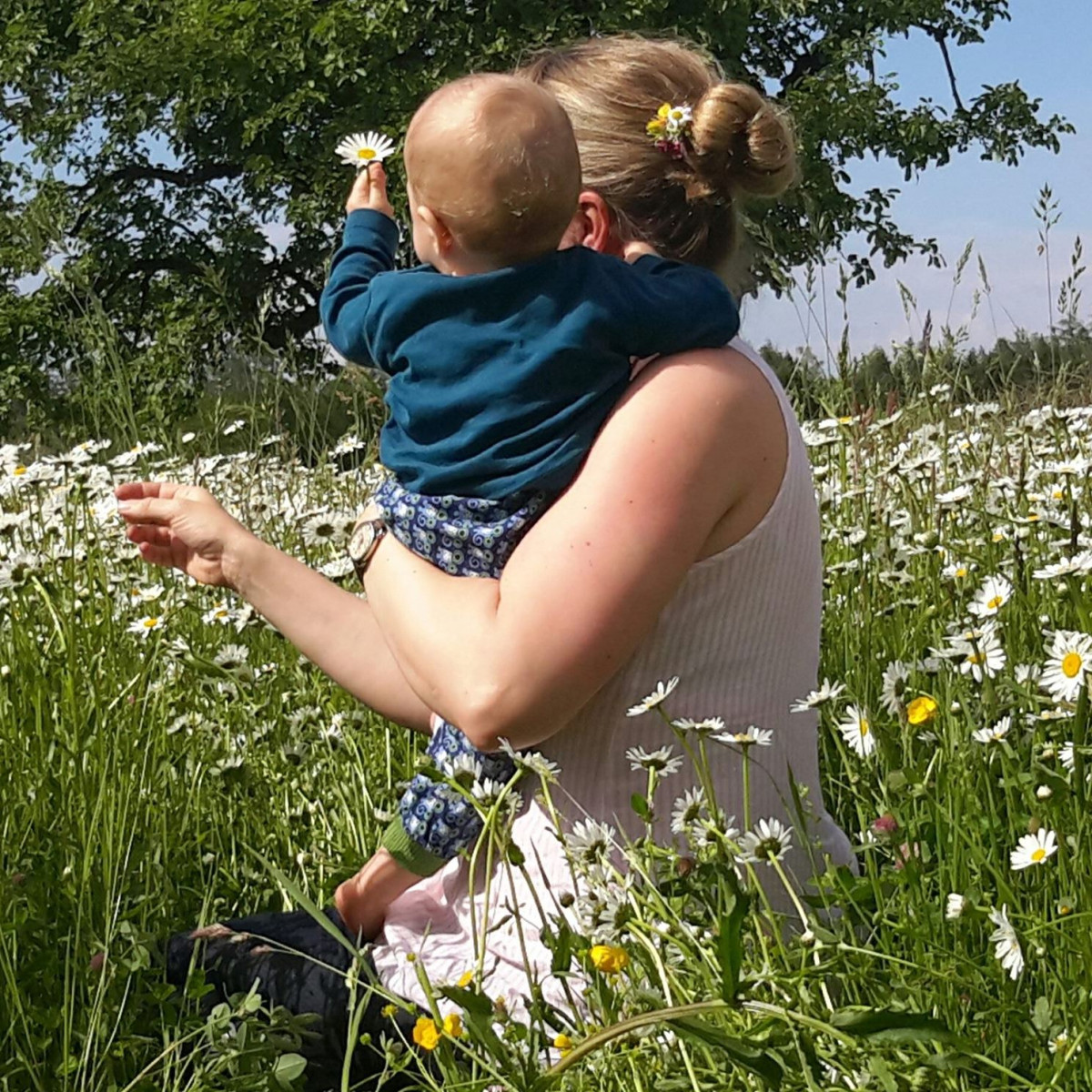 Mutter Daniela Ehm zeigt ihrem Sohn, die Blüten, die auf dem Blütenmeer-Rasen wachsen