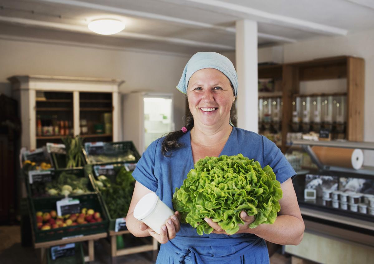 Bäuerin im Hofladen mit Produkten