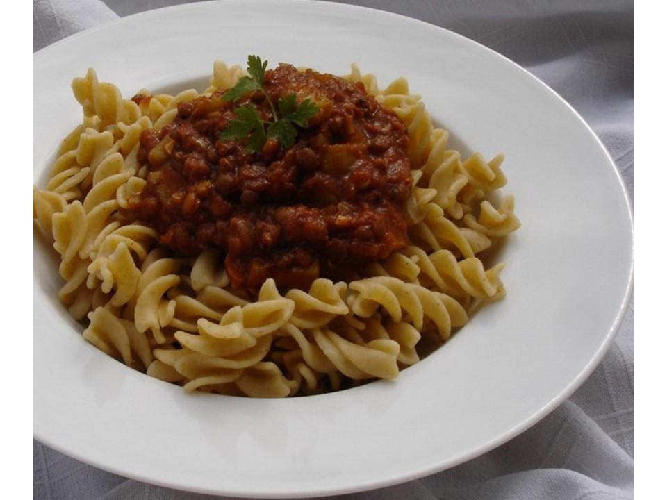 Teller mit Nudeln und Bolognese mit Petersilie garniert