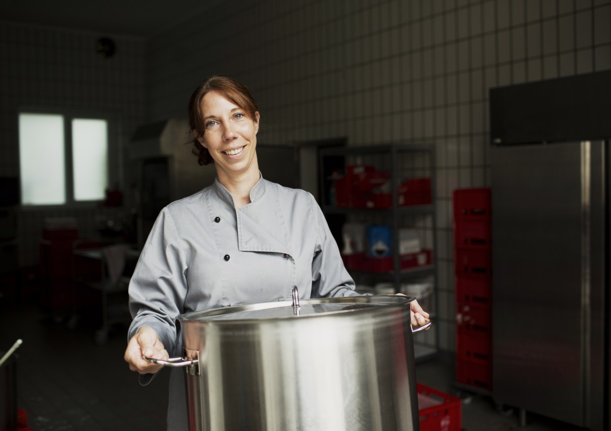 Catererin Yvonne Vordermayr-Fischer mit einem großen Topf in der Hand in ihrer Küche in Hirten/Burgkirchen a.d.Alz