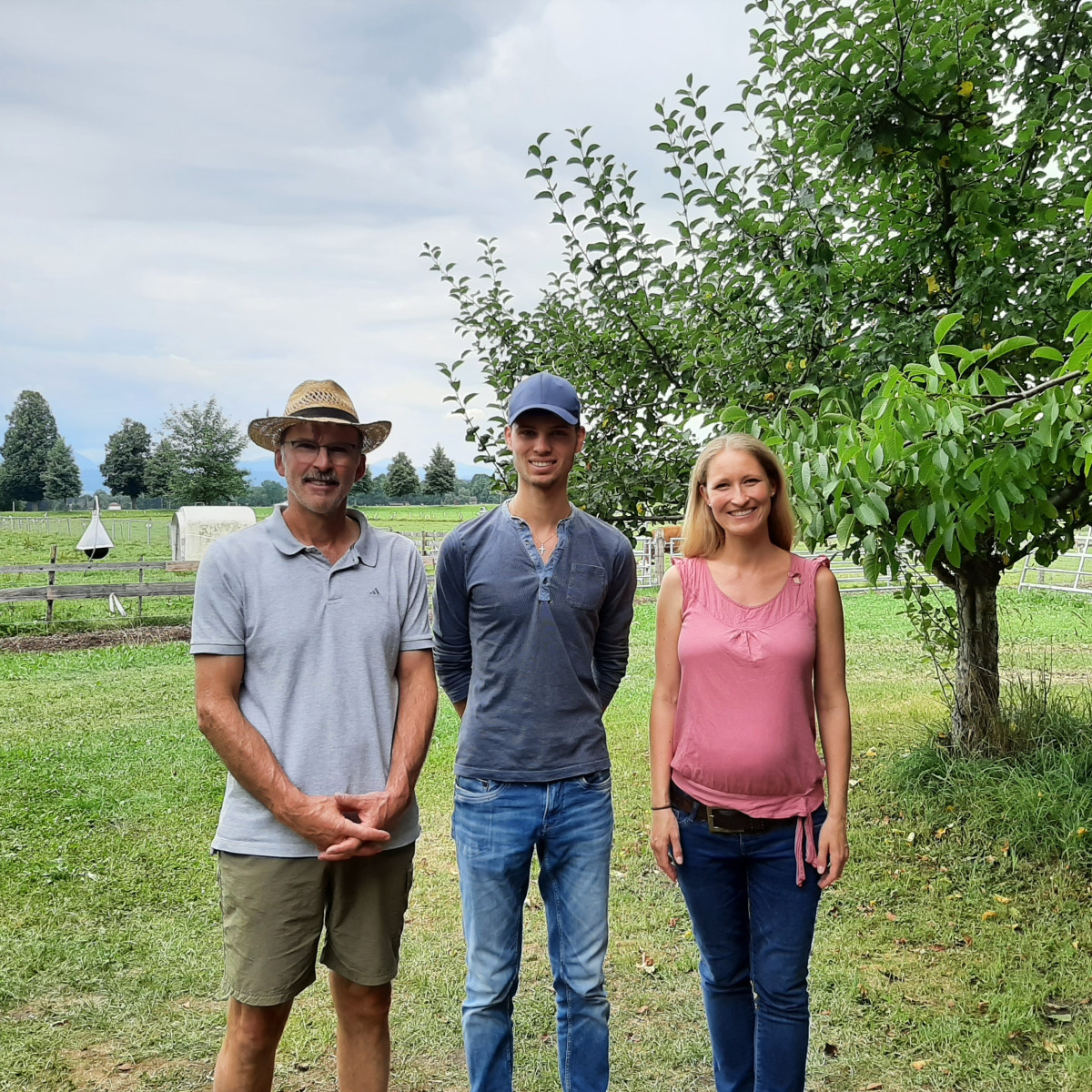 Xaver und Georg Gartmeier stehen zusammen mit Verena Pickert von der ÖMR auf einer Wiese