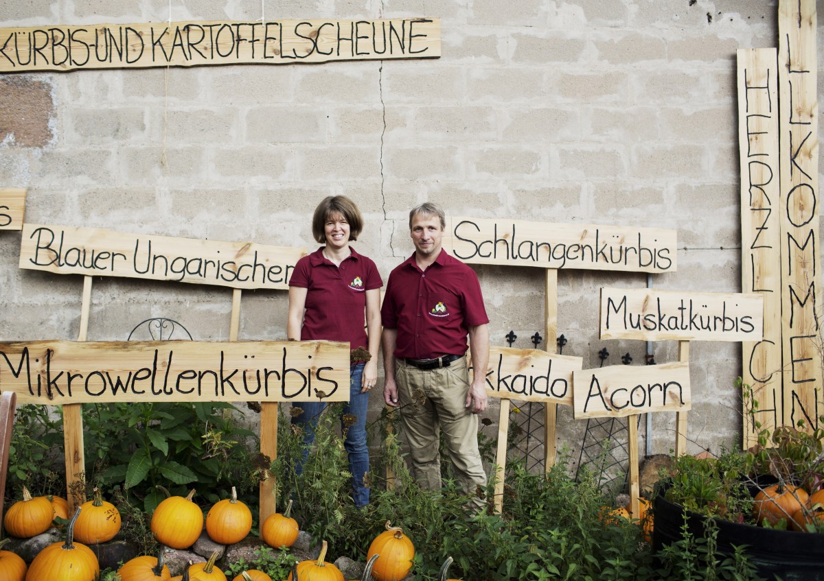 zwei Personen zwischen Schildern mit Kürbisnamen
