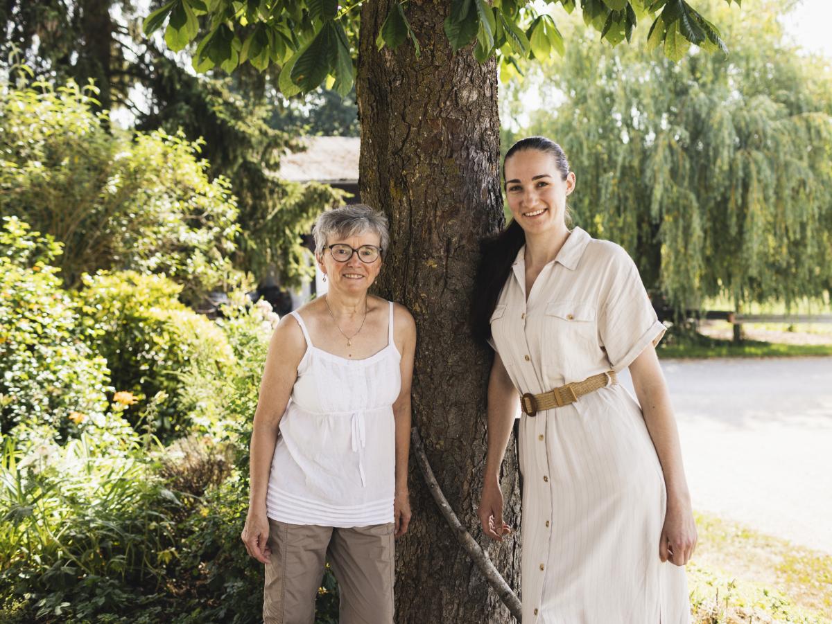 Zwei Frauen stehen unter einem Baum.