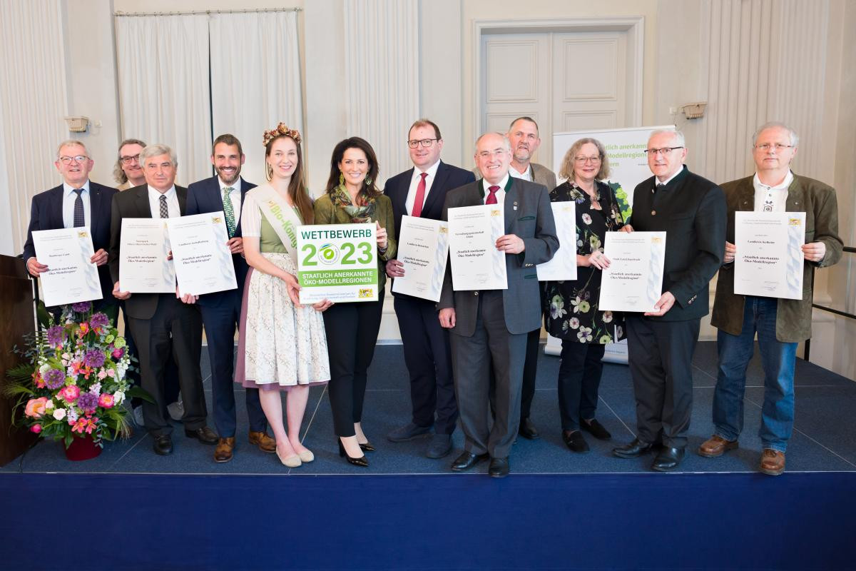 Gruppenfoto der Verleihung mit Ministerin Michaela Kaniber, Bio-Königin Raphaela I. (7.u.8.v.r) und den Vertreterinnen und Vertretern der neuen Ökomodellregionen