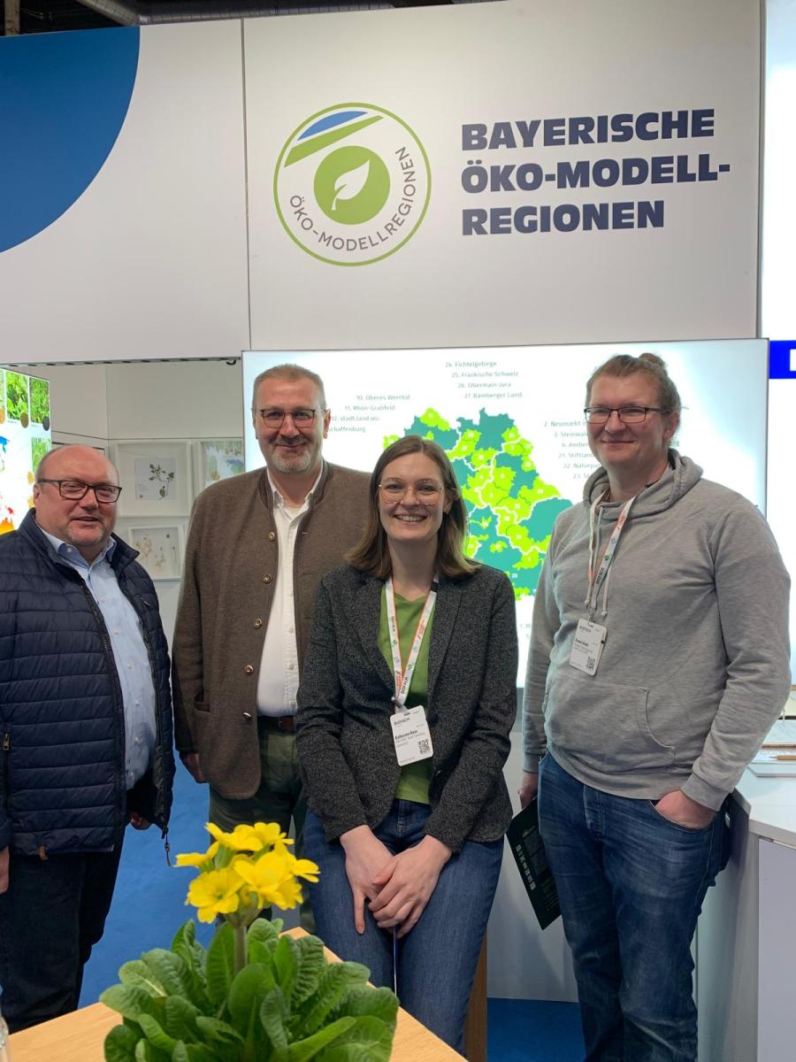 Gruppe am Stand der Öko-Modellregionen
