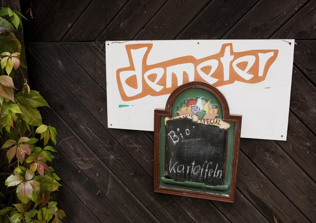 ein Schild mit der Aufschrift "Bio-Kartoffeln" hängt an einem Hoftor