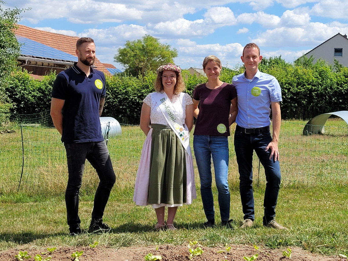 Die Bayerische Bio-Königin mit Christoph Rothhaupt, Sarah Walz und Daniel Flach, im Vordergrund Salatpflanzen