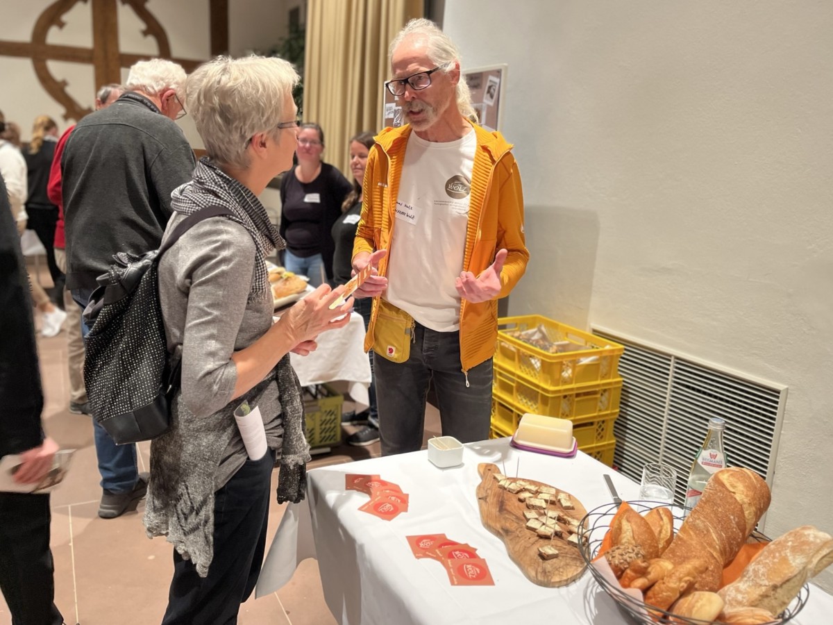 Zwei Menschen bei der Unterhaltung, auf dem Tisch Backwaren