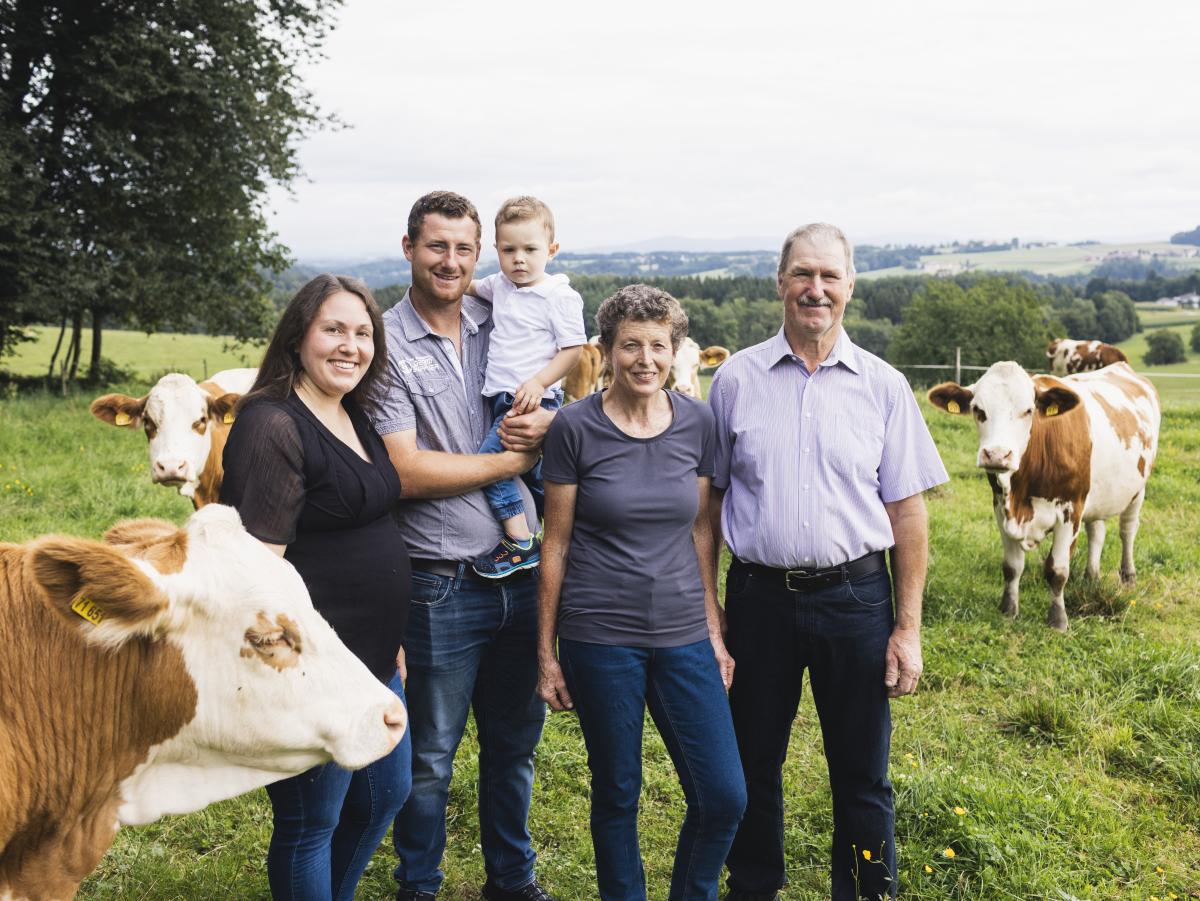 Familie steht auf Kuhweide