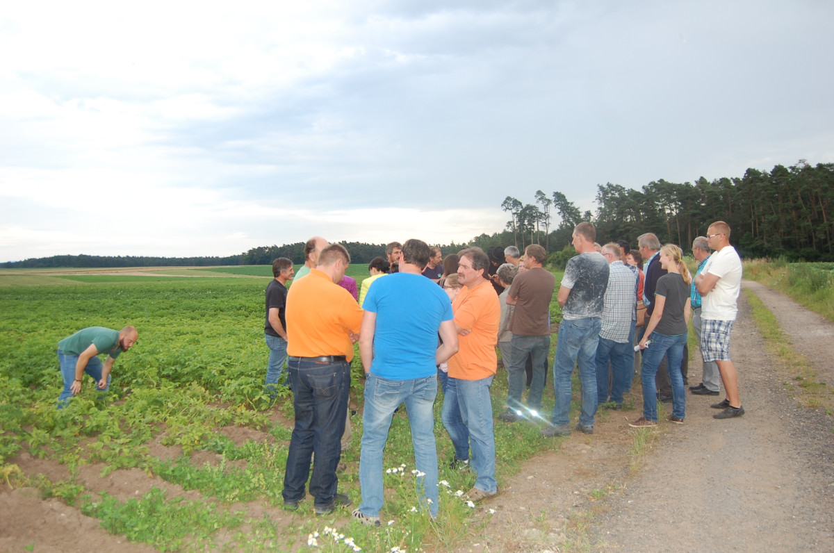 Gruppe mit ca. 30 Personen/Landwirten steht am Feldrand