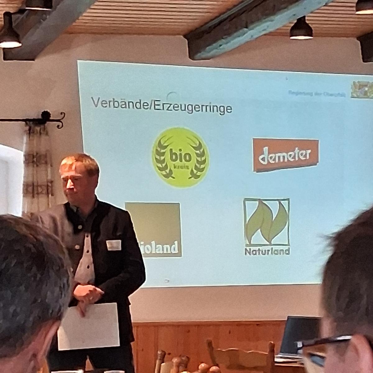 ein Mann steht vor Publikum und begrüßt dieses