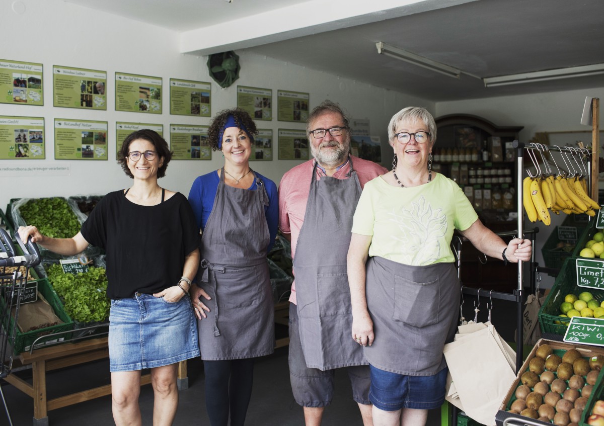 Die Crew von Radis & Bona umringt von bio-regionalem Gemüse und Obst