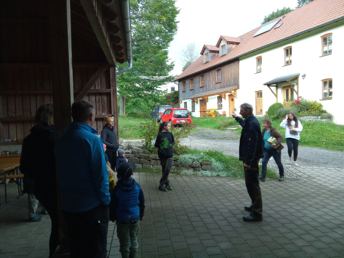 eine Gruppe von Leuten steht auf einem Bauernhof