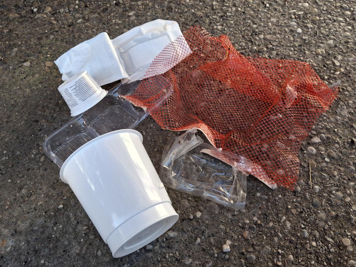 Lebensmittelverpackungen: weiße Kunststoffbecher, transparente Kunstsoffverpackungen, rotes Kunststoffnetz