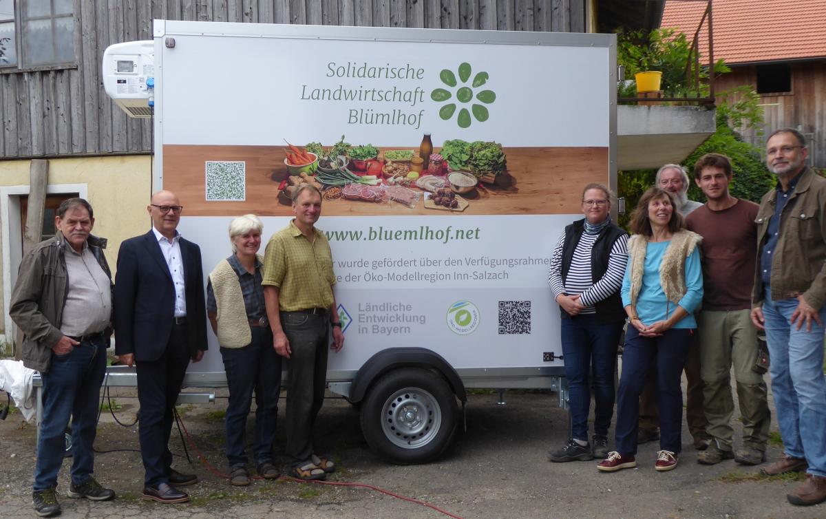 Neun Personen stehen vor dem Kühlanhänger.