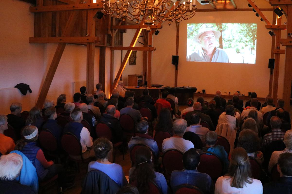 Viele Menschen sitzen in einem Saal und schauen einen Film