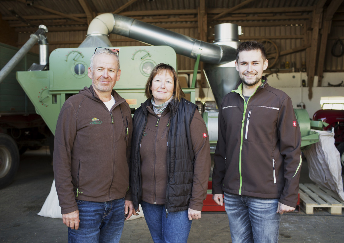 Drei Erwachsene vor einer Siebreinigungsanlage