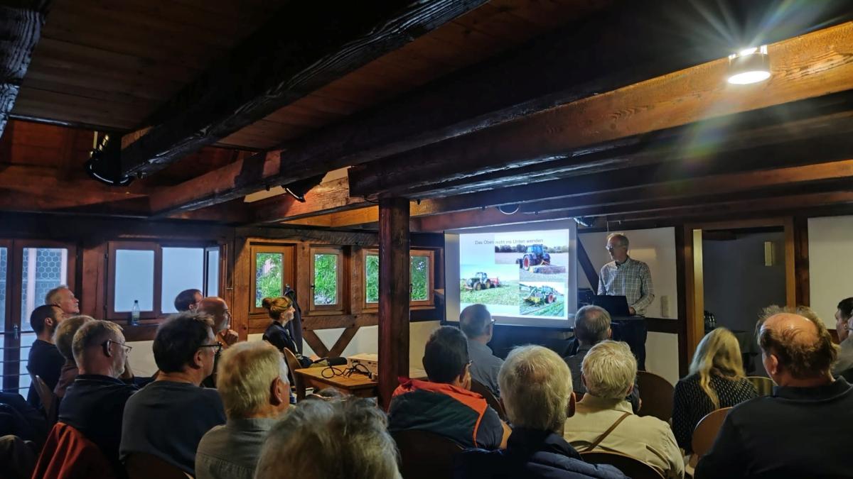 Menschen in einem Saal vor einem Vortragenden