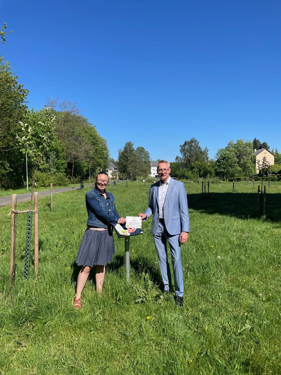 2 Personen mit Hinweisschild