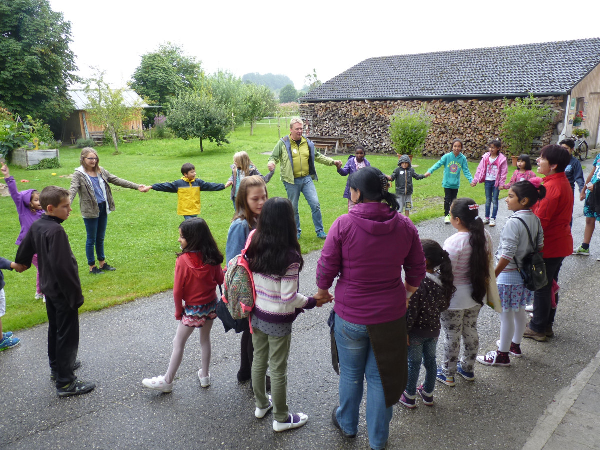 Kinder und Erwachsene in einem Kreis im Freien