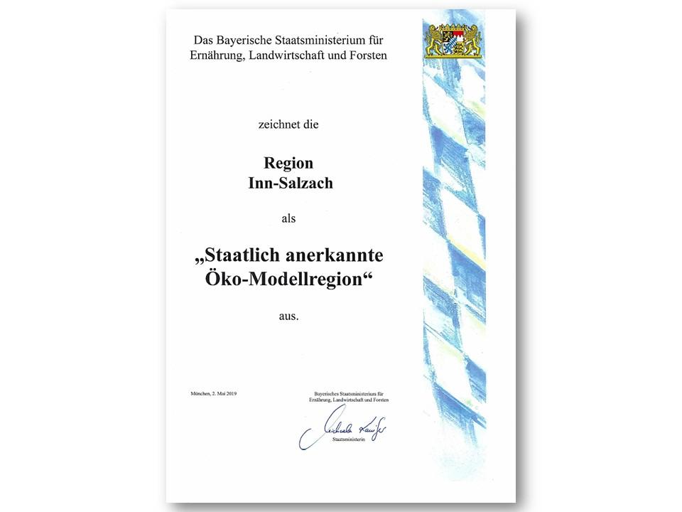 Urkunde des StmELF, unterschrieben von Ministerin Kaniber. Am rechten Rand sind blau-weiße bayerische Rauten und rechts oben ist das Bayerische Wappen mit den zwei Löwen abgebildet.