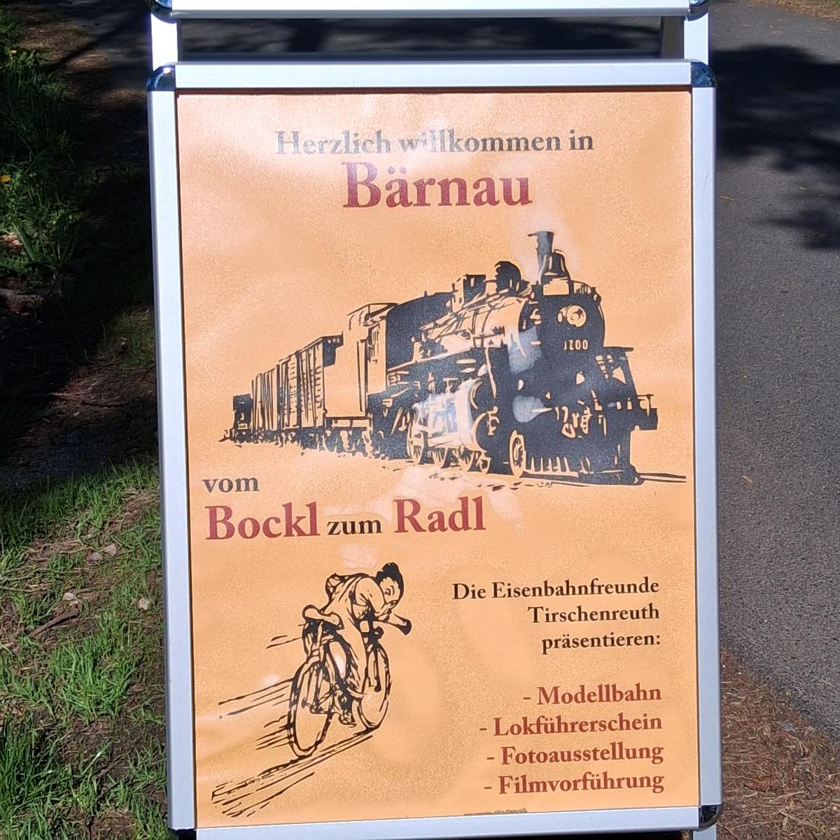 ein Schild mit einer Dampflok und einem Fahrradfahrer