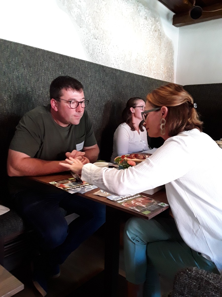Ein Mann unterhält sich mit einer Frau an einem Tisch.