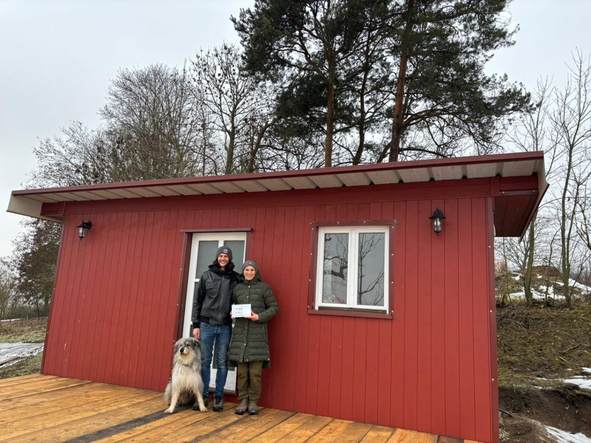 Stefanie und Peter Riegg stehen mit ihrem Hund vor dem fertigen Tinyhouse