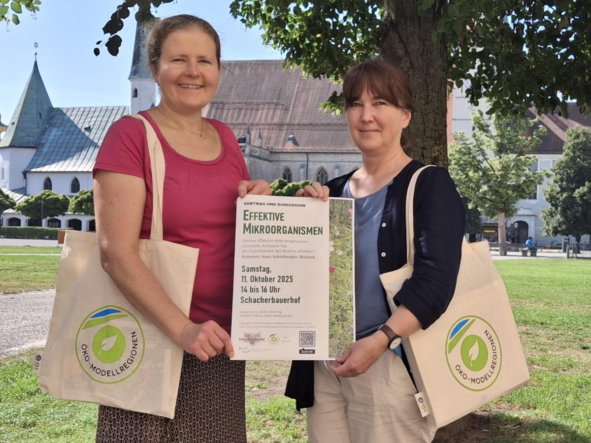 Zwei Frauen präsentieren ein Plakat für die Veranstaltung