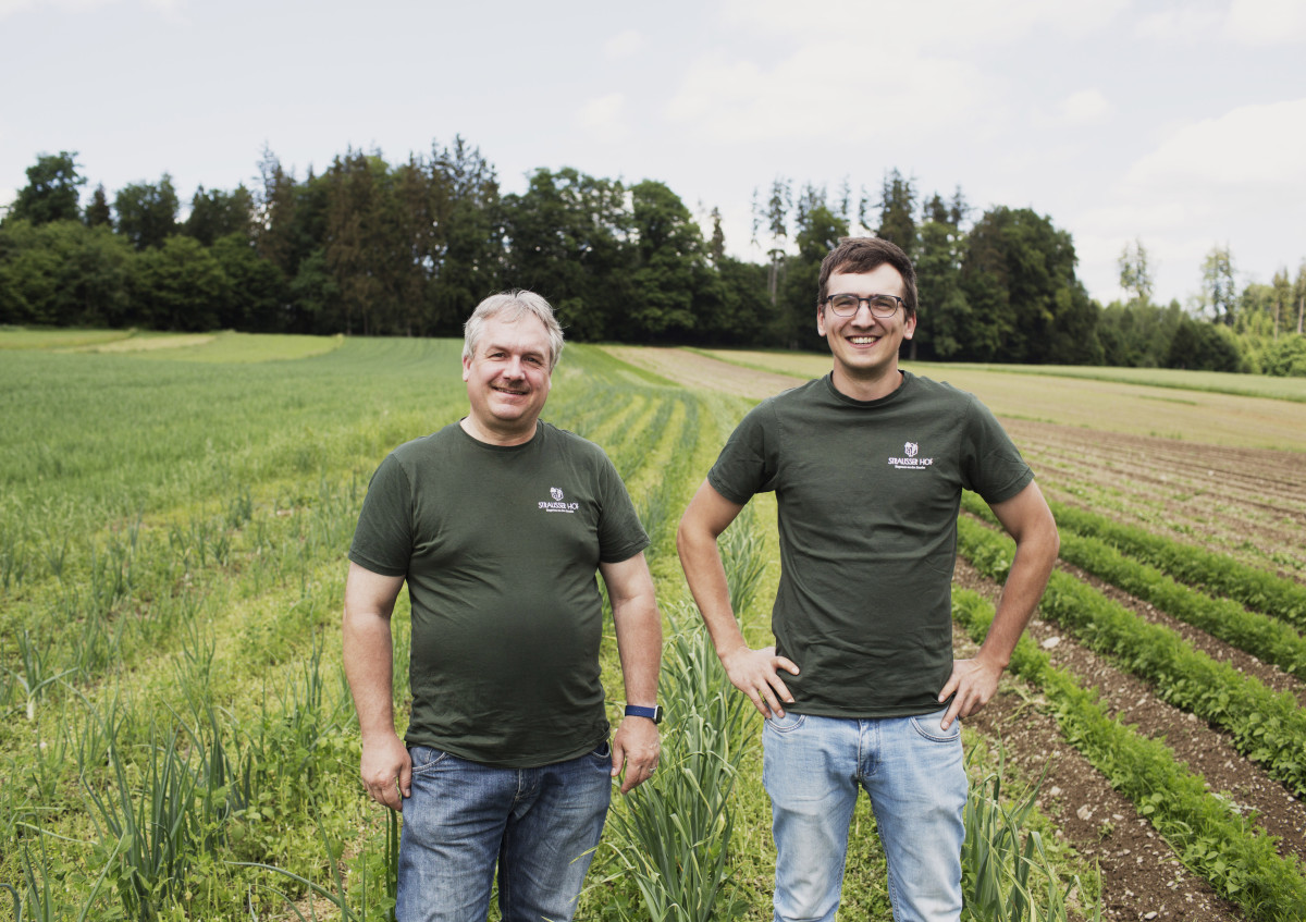 Das Foto zeigt zwei Männer auf einem Feld.