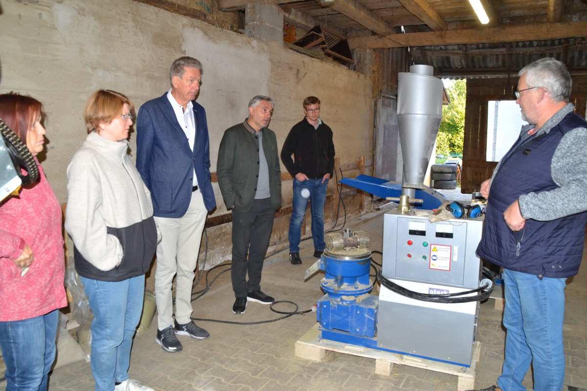 Thomas Frank (rechts) erklärt die Herstellung von Bio-Futterpellets für Kleintiere aus hofeigenen Komponenten wie etwa Getreide, Ackerbohne und Kleegras.