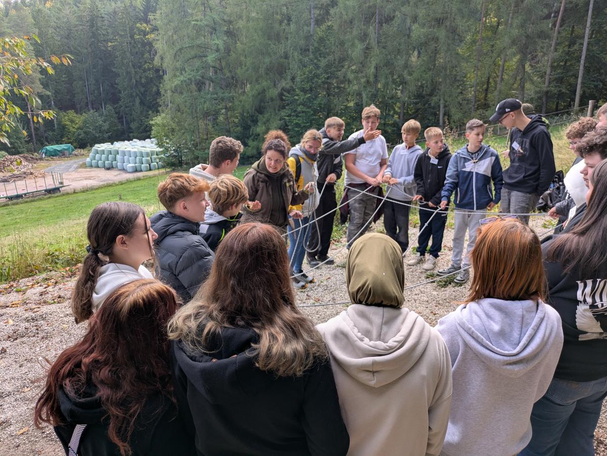 Die Schülerinnen und Schüler symbolisieren die Artenvielfalt mit einem Netz, das von allen gehalten wird.