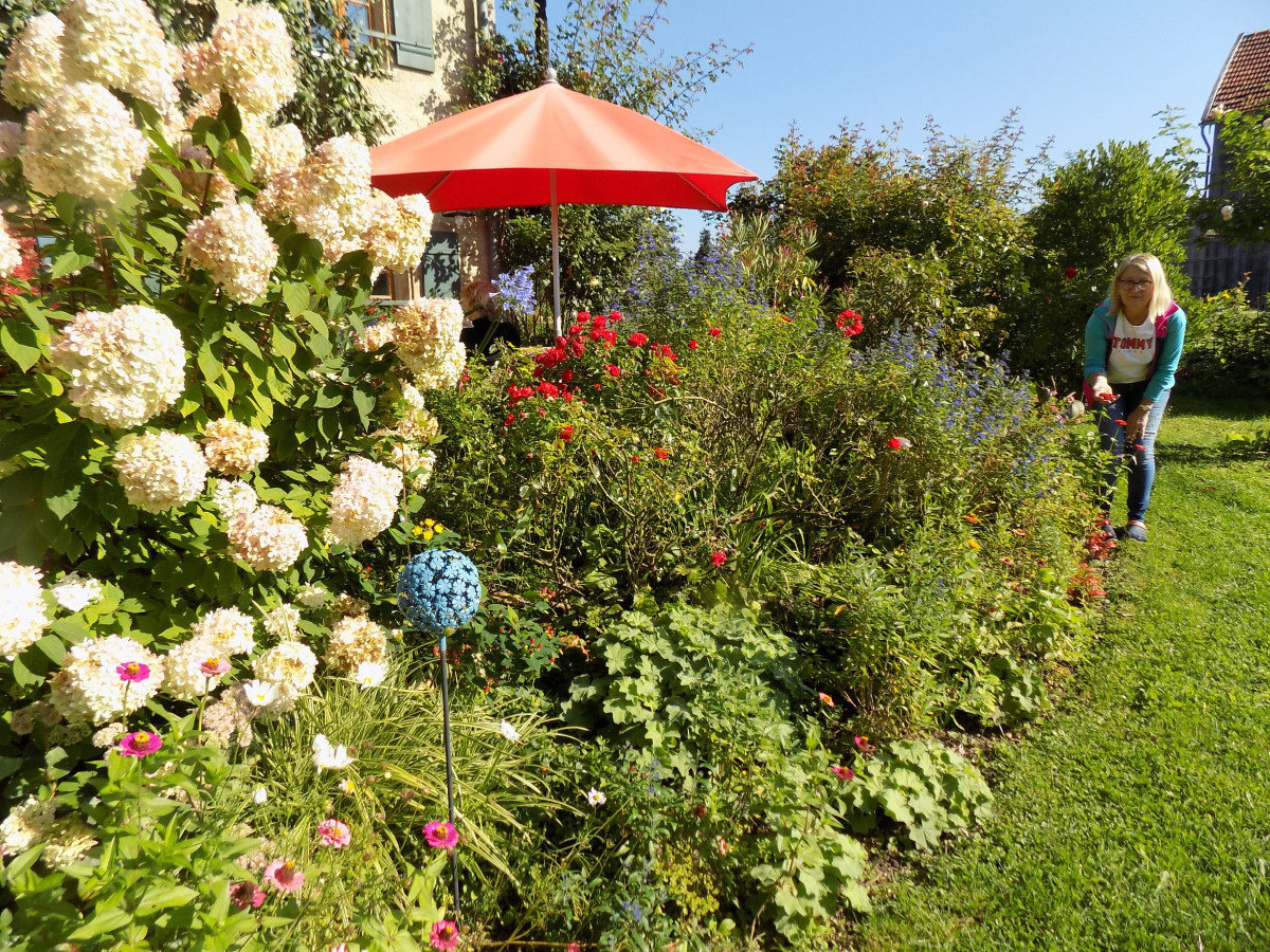 Irmi Rackerseder, stellvertretende Vorsitzende des Kirchanschöringer Obst- und Gartenbauvereins Kirchanschöring vor einem spätsommerlichen Blumenbeet vor ihrem Haus.