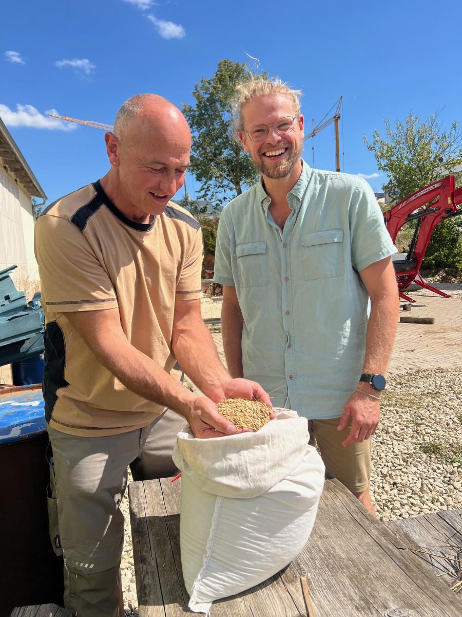 Biolandwirt Josef Beck und Felix Wiedner, Projektmanager der Ökomodellregion Stadt.Land.Ingolstadt schauen sich die Gerste im Sack an