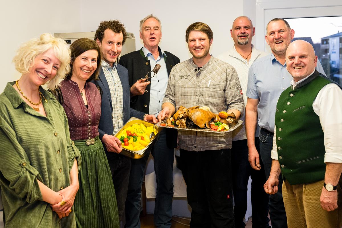 Menschen stehen im Halbkreis mit Essen in den Händen
