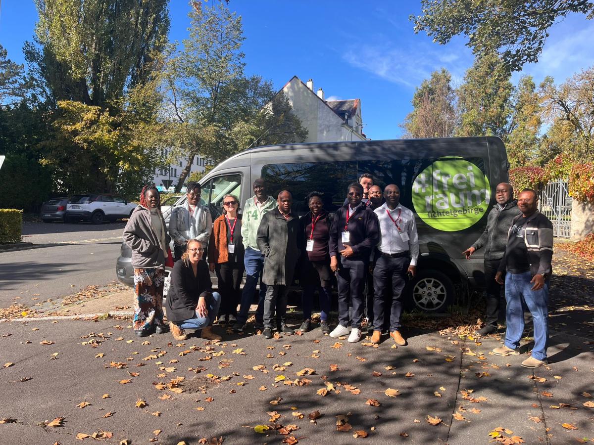 Menschengruppe vor Bus mit Freiraum für Macher Logo