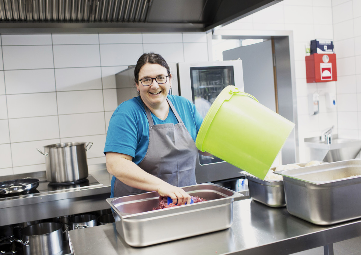 Köchin in der Profiküche bei der Zubereitung des Mittagessens.