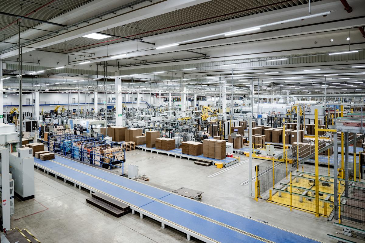 eine große Fertigungshalle mit Förderbändern und Maschinen
