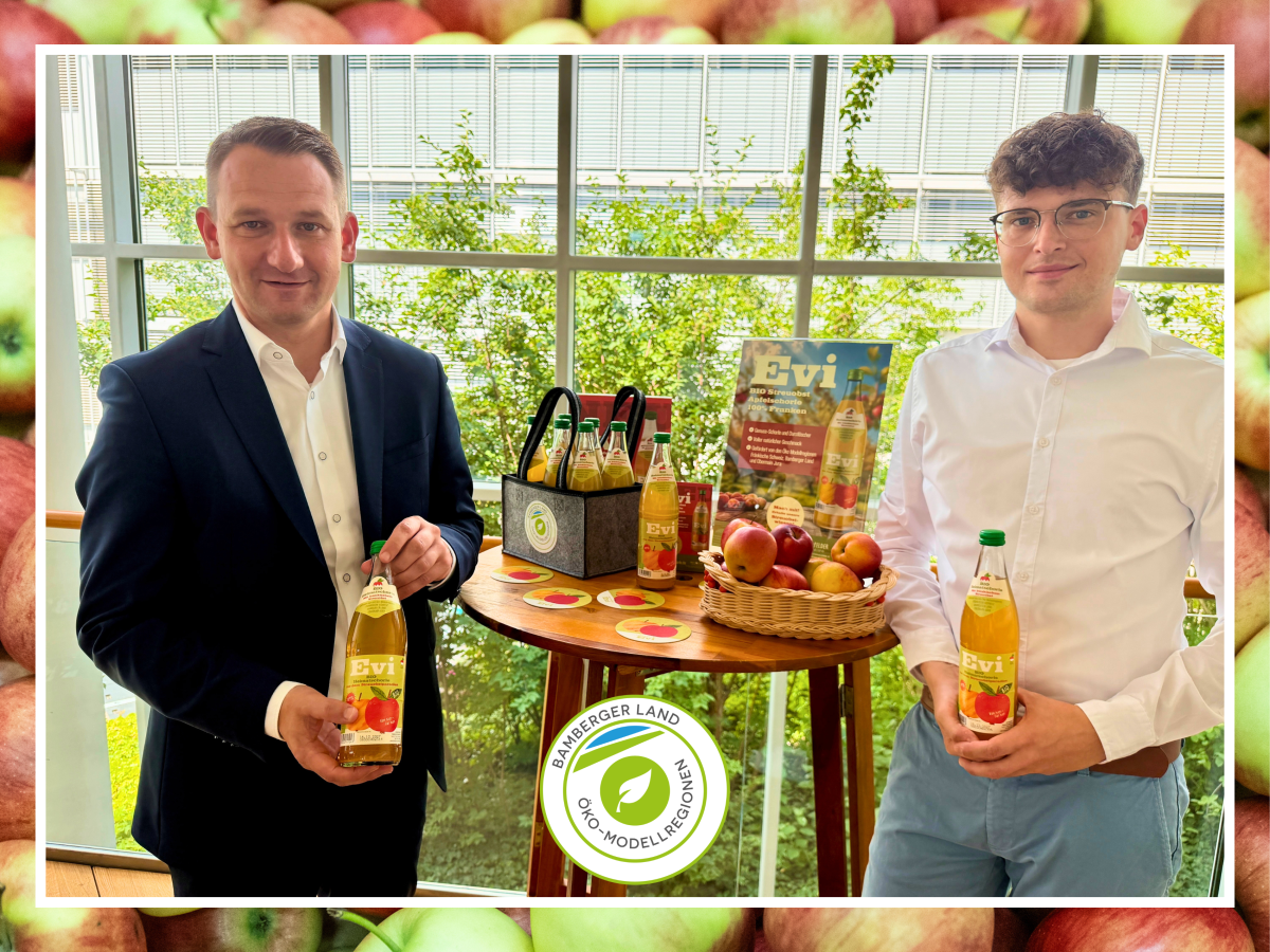 Personen stehen am Messestand uind halten eine Flasche Apfelschorle