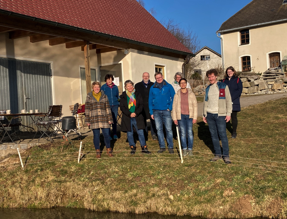 1. Reihe v.l.: Anna Schwamberger, Gisela Sengl, Peter & Martina Fuhrmann, Jonas Bierlein und Antje Grüner (ÖMR Stiftland), Eva Gibhardt und Günther Erhardt (ÖMR Steinwald-Allianz) und Gertraud Haberkorn stehen hinter einem Fischteich der Familie Fuhrmann