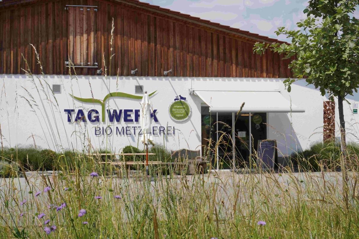 Das Foto zeigt ein Gebäude mit dem Schriftzug Tagwerk.