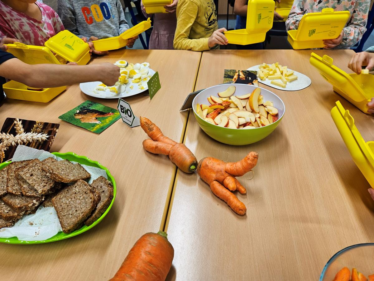 Frühstücksbüfett und Kinder mit gelben Brotboxen